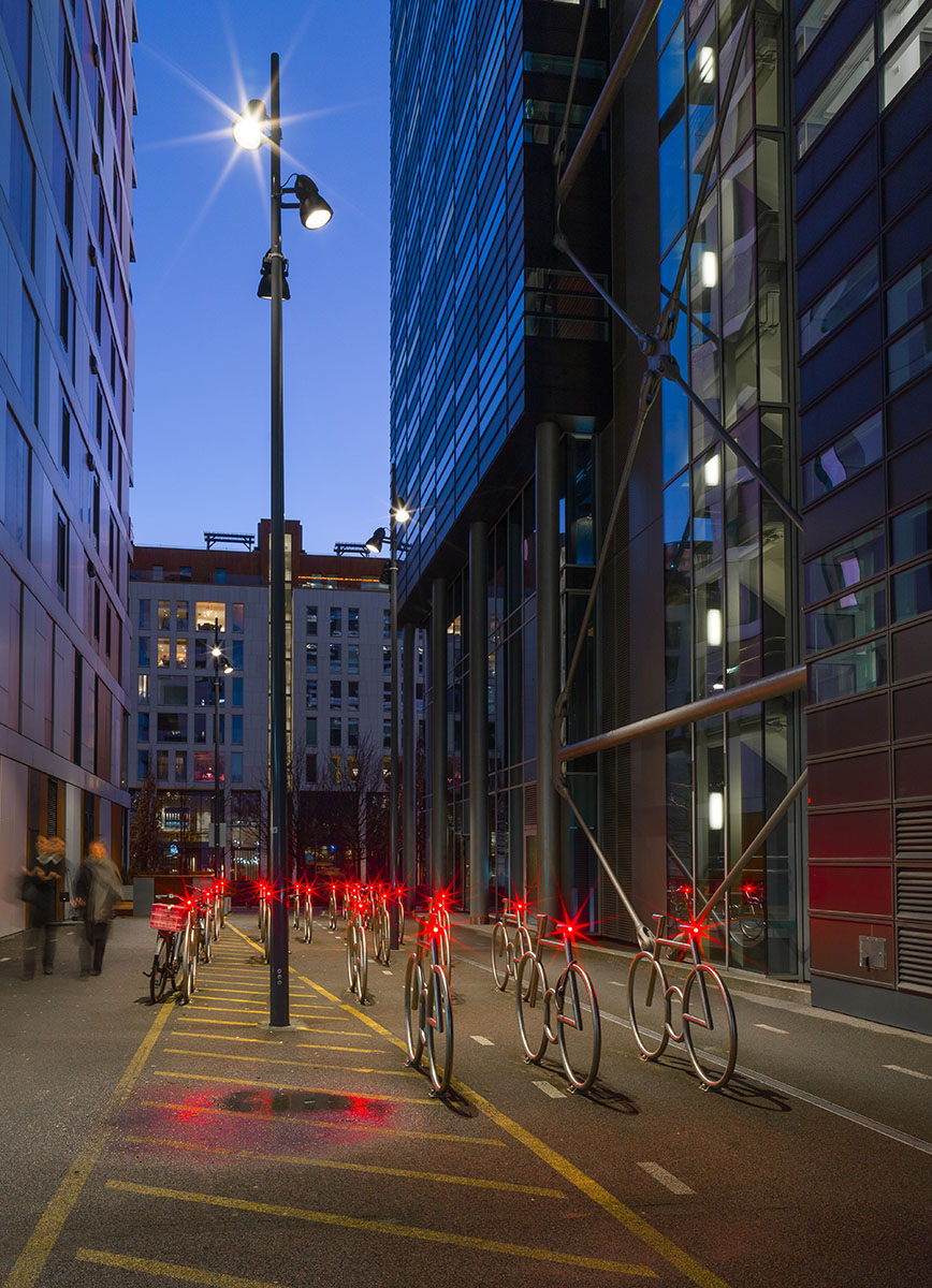 Tapered light poles illuminate an original bicycle parking facility in Oslo. Photo: Glenn Røkeberg