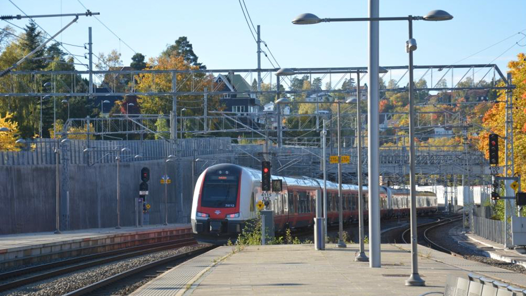 Kjøreledningsmaster og åk langs jernbanen.